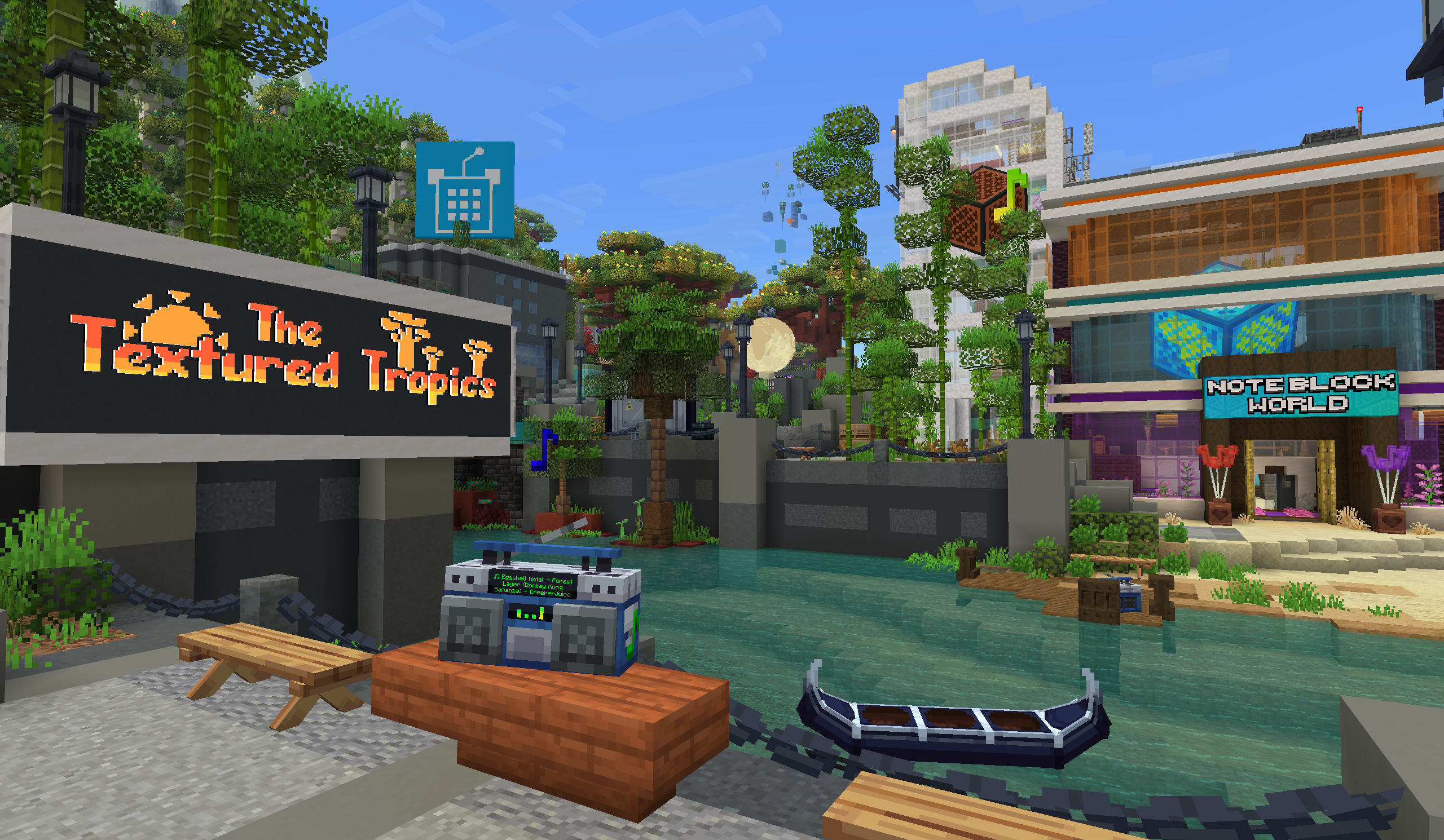 OpenNBS booth across a river in the Textured Tropics, with a Note Block World building and a speaker on a riverside table.
