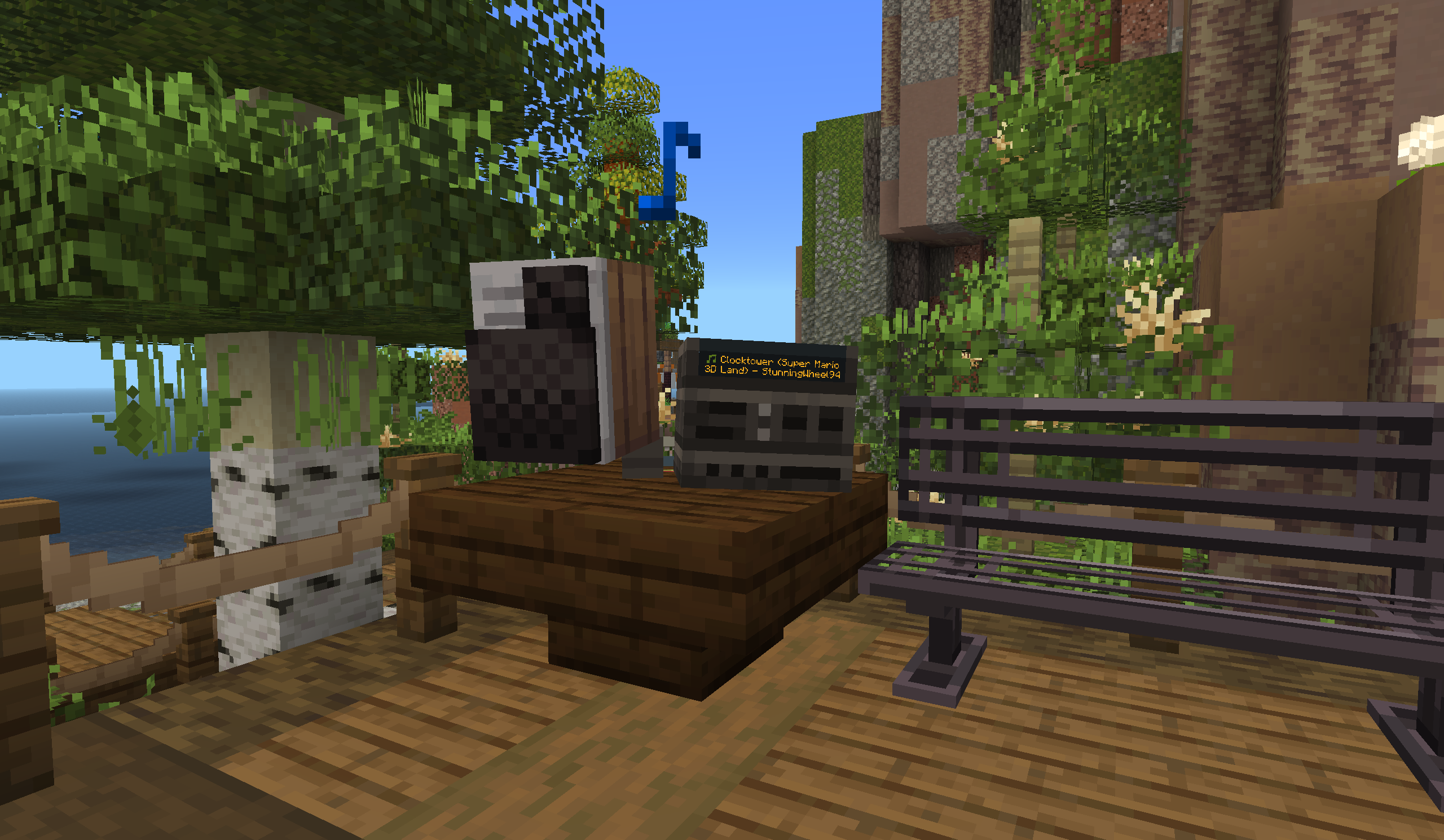 Wooden music speaker on a birch deck, with a floating blue note particle and water in the background.